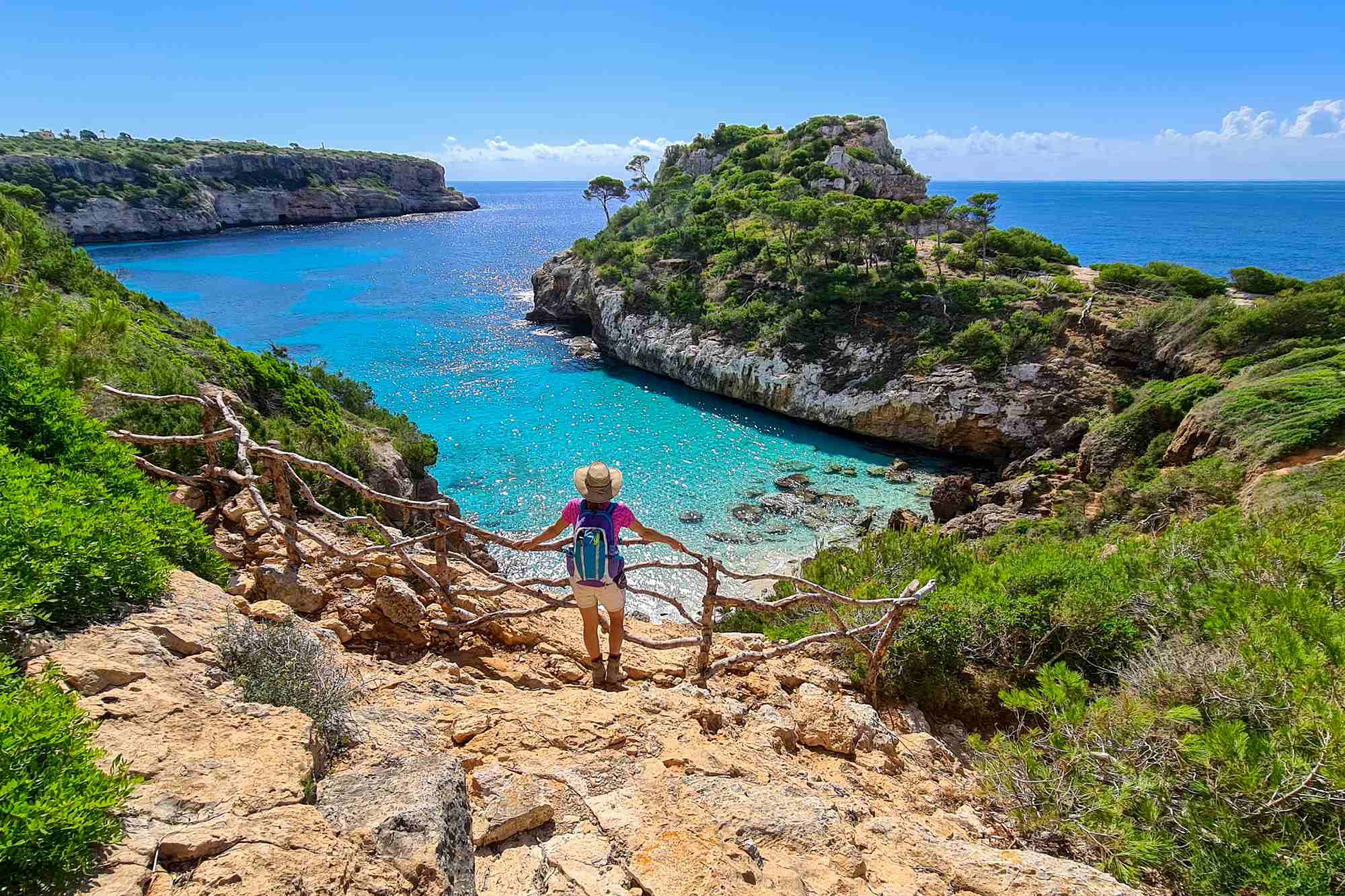 Touristin mit Sonnenhut und Rucksack genießt die Aussicht auf Mallorca
